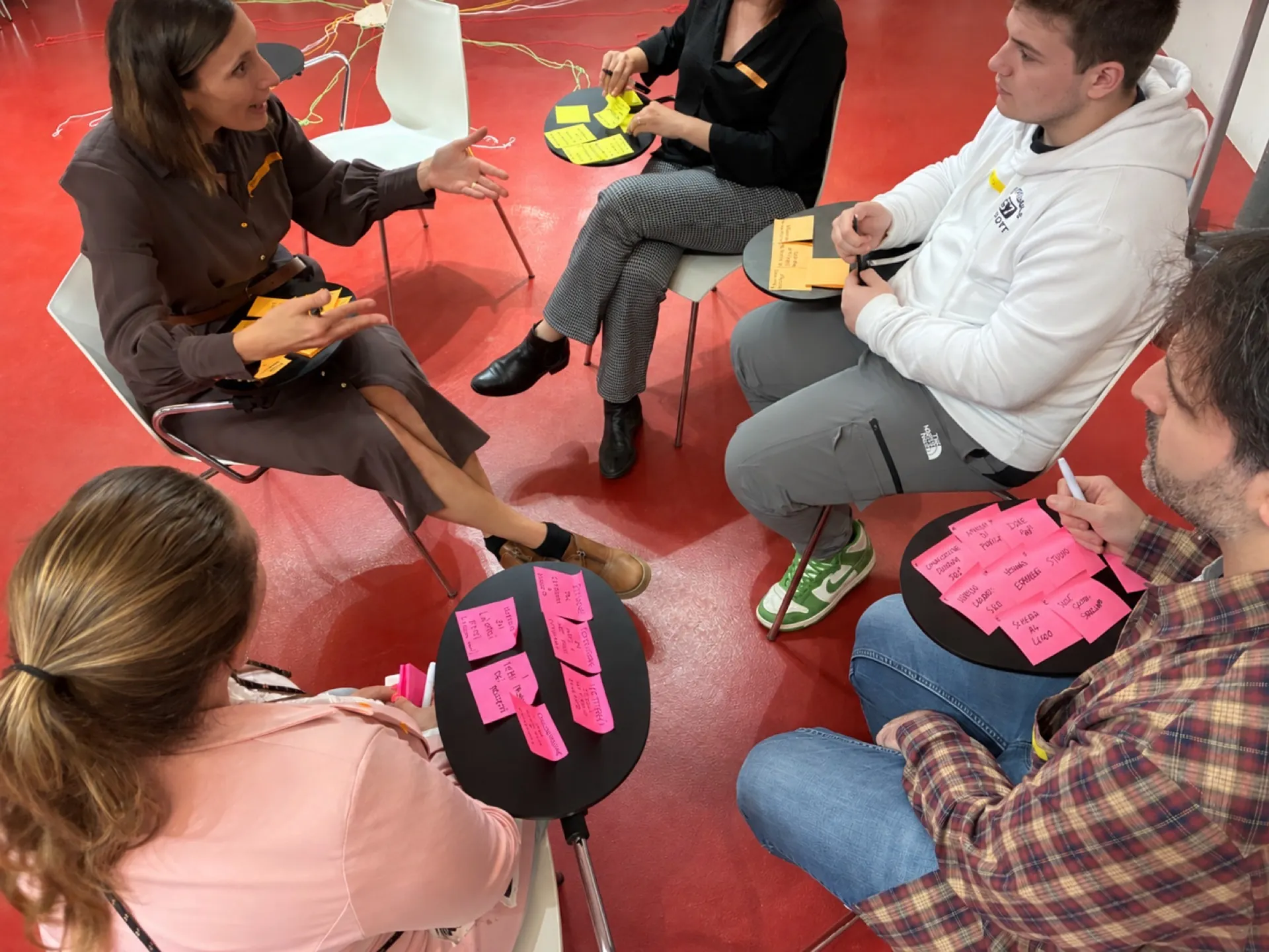 Un gruppo intergenerazionale confronta esperienze e bisogni formativi durante un’attività facilitata.