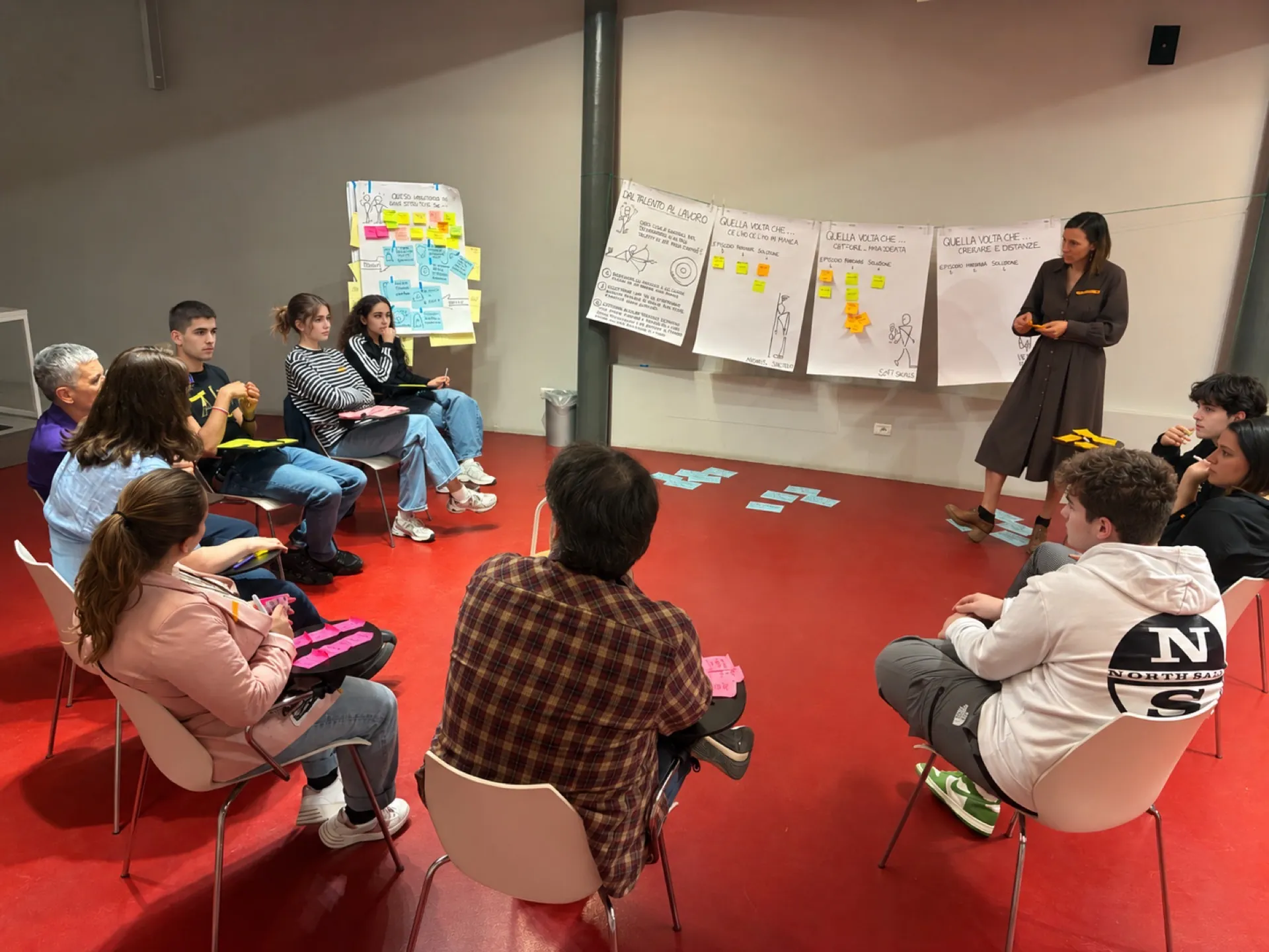 Partecipanti di generazioni diverse si confrontano in cerchio su esperienze, aspettative e bisogni legati al lavoro.