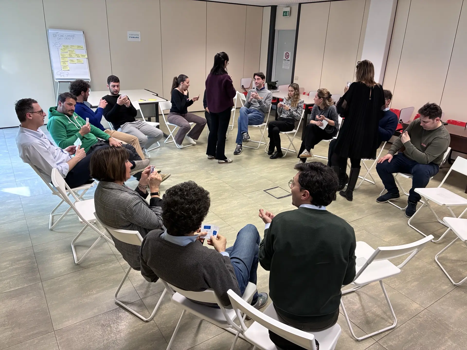 I partecipanti, seduti in cerchio, svolgono un’attività esperienziale per allenare feedback e problem solving collaborativo.