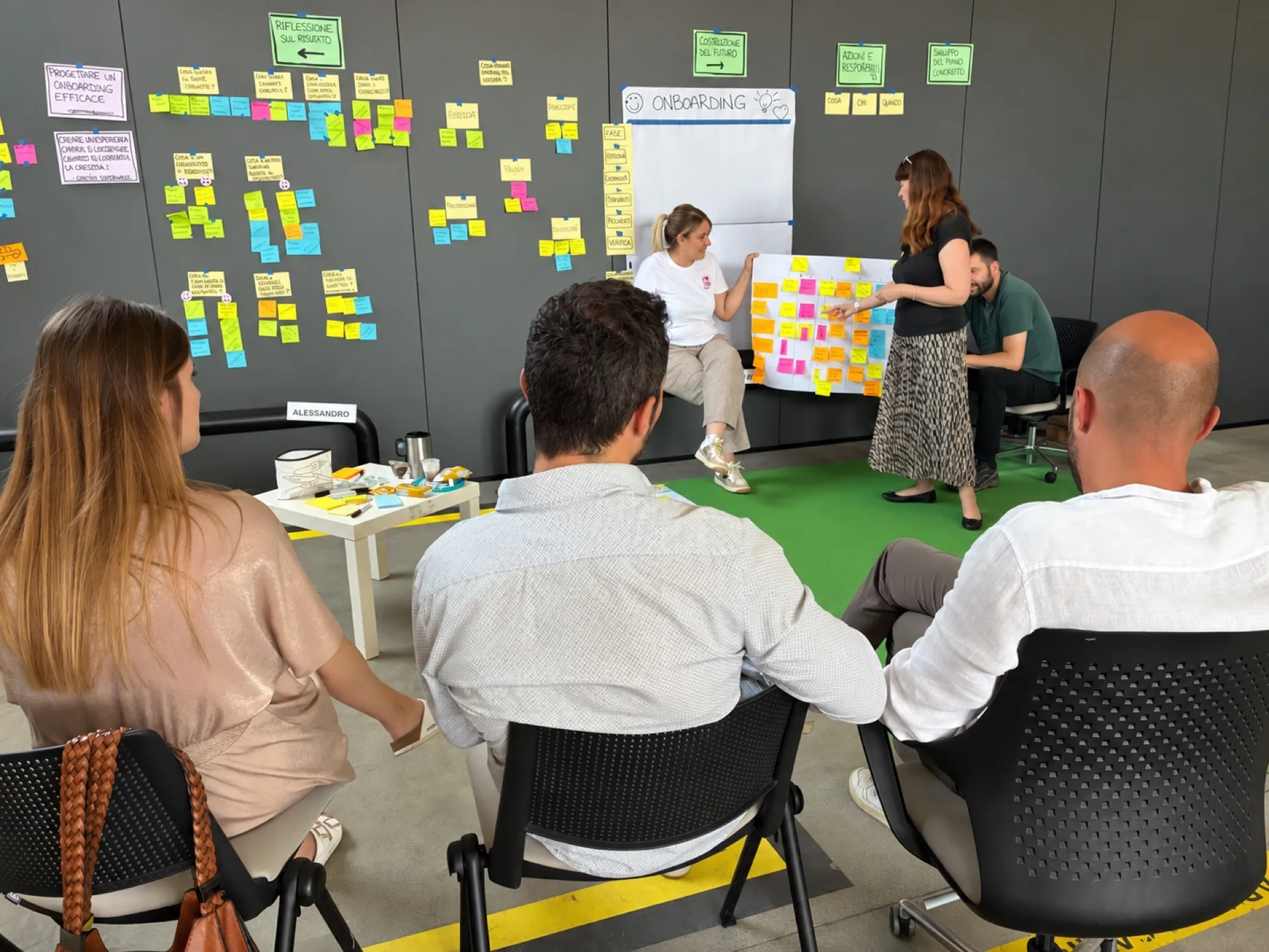 Una partecipante presenta al gruppo il percorso di onboarding co-progettato attraverso i contributi raccolti.